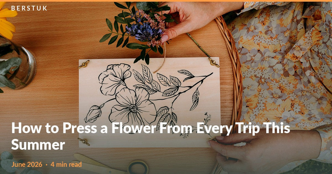 Top-down view of hands arranging fresh flowers on an open Berstuk Travel Flower Press at an outdoor table