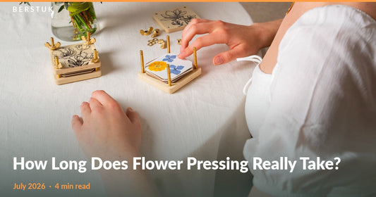 An open Berstuk Miniature Flower Press with yellow and blue pressed flowers beside a closed press and a fresh bouquet