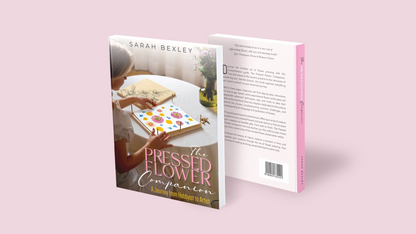 Front and back covers of 'The Pressed Flower Companion: A Journey from Hobbyist to Artist' by Sarah Bexley displayed together against a pink background, with the back cover showing a description and barcode.