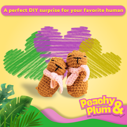Two crocheted capybaras hugging with a heart and 'Peachy Plum' branding on a yellow background.