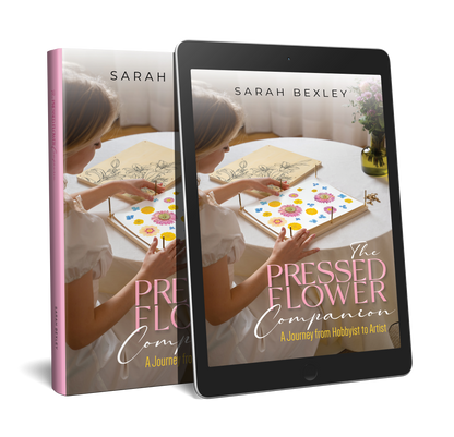 Book cover mockup for 'The Pressed Flower Companion: A Journey from Hobbyist to Artist' by Sarah Bexley, shown on a printed book with pink spine and displayed on a tablet screen, featuring a photo of hands arranging pressed flowers on a table.