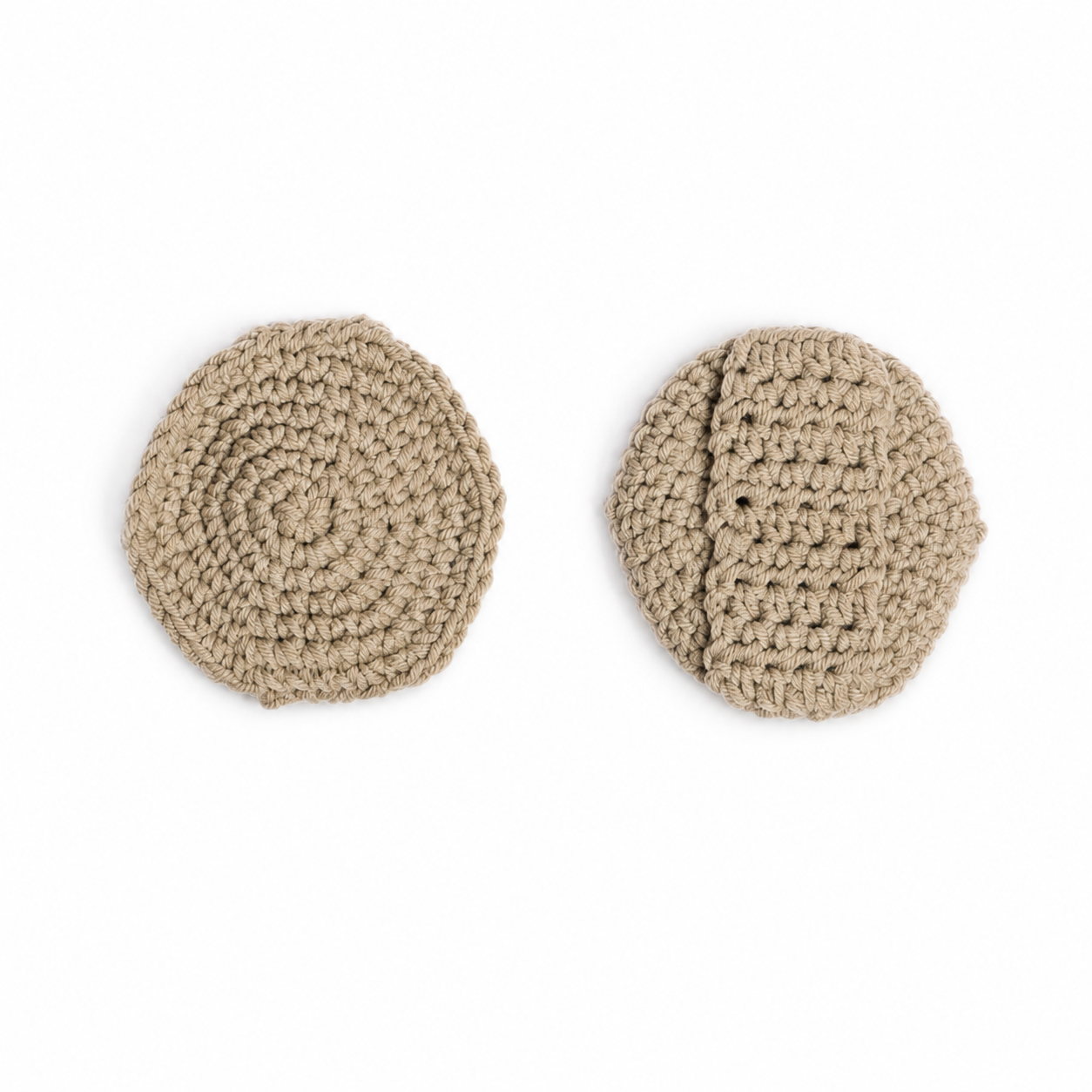 Two round sage crocheted face scrubbies shown flat against a white background, one displaying the textured spiral pattern from the inside and the other showing the stitched exterior.
